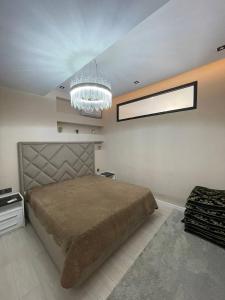ドゥシャンベにあるComfort apartmentの大きなベッドとシャンデリアのある寝室