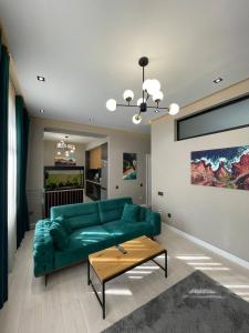 ドゥシャンベにあるComfort apartmentの緑のソファとテーブルのあるリビングルーム