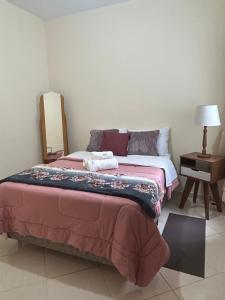 a bedroom with a bed and a table with a lamp at Elite na Serra in Cunha +2 photos