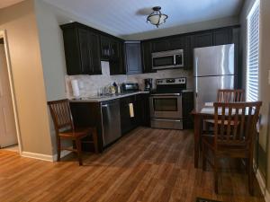 eine Küche mit schwarzen Schränken und Edelstahlgeräten in der Unterkunft Golden Pines Villa on Choice Ave Steps to Downtown in Dahlonega