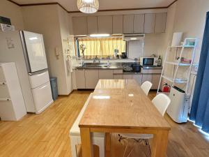 cocina con mesa de madera y electrodomésticos blancos en Taga House, en Awaji 16 fotos más