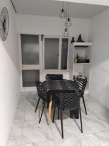 a dining room with a black table and chairs at LA Helena in Ezeiza +1 photo