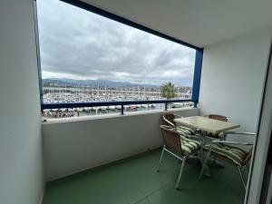 アンダイエにあるCharmant studio avec piscine à Hendaye - FR-1-239-1148の港の景色を望むバルコニー(テーブル、椅子付)