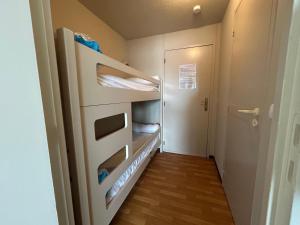 アンダイエにあるCharmant studio avec piscine à Hendaye - FR-1-239-1148の小さな客室で、冷蔵庫、廊下が備わります。