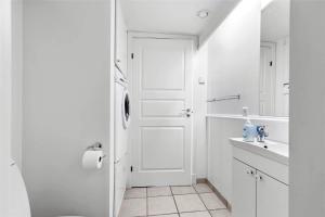 a white bathroom with a door and a sink at 11207-Nykobing-Sj-Havnevej-65-1-th in Nykøbing Sjælland +14 photos