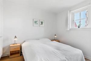 a white bedroom with a bed and a window at 11207-Nykobing-Sj-Havnevej-65-1-th in Nykøbing Sjælland