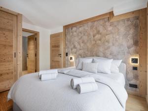 a bedroom with a large white bed with two towels on it at Appartement neuf au pied des pistes, sauna, 5 chambres pour 12 personnes - FR-1-570-71 in Levassaix