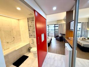 a bathroom with a toilet and a tub and a sink at Lindo Studio com Jacuzzi e sacada a 50m Av Paulista in Sao Paulo +23 photos