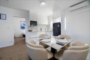 a kitchen with a table and chairs and a refrigerator at Grand Riccarton Hotel in Christchurch +27 photos