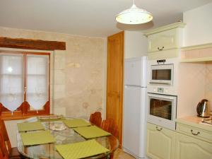 a kitchen with a table and a white refrigerator at Authentique Maison de Vigneron XIXe au Coeur du Val de Loire, 4 Chambres, Parking, Jardin - FR-1-381-126 in Cangey +5 photos