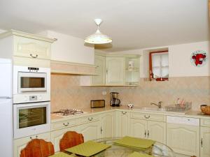 a kitchen with white cabinets and a glass table at Authentique Maison de Vigneron XIXe au Coeur du Val de Loire, 4 Chambres, Parking, Jardin - FR-1-381-126 in Cangey