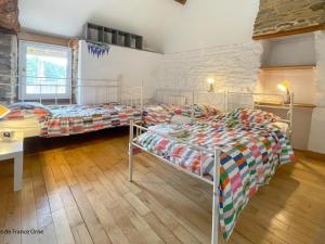 2 łóżka w pokoju ze stołem i biurkiem w obiekcie Maison spacieuse avec spa et jardin dans le bocage normand - FR-1-497-254 w mieście Mantilly