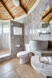 a bathroom with a sink and a toilet and a tub at Midas Belize in San Ignacio