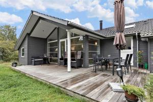 a house with a wooden deck with a table and chairs at 11802-Nykobing-Sj-Gogetoften-10 in Nyrup