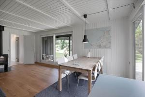 a dining room with a wooden table and chairs at 12215-Sjaellands-Odde-Granitager-8 in Tjørneholm