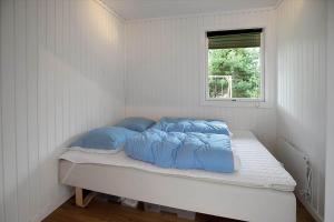 a bed in a white room with a window at 12215-Sjaellands-Odde-Granitager-8 in Tjørneholm