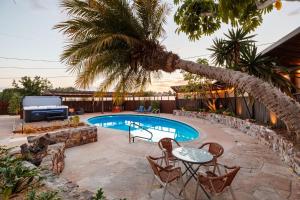 Una piscina con sillas y una mesa y una palmera. en Luxury Point Loma Retreat Pool Spa Views, en San Diego