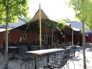 a table and chairs under a tent on a patio at Holiday home on the recreational lake in Lathum