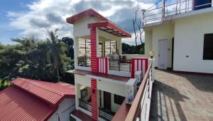 a house with a red and white balcony at Pring Pension House Puerto Princesa in Puerto Princesa City