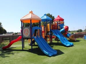 a group of playground equipment on a grass field at Chalet in Gelderland with Hot Tub in Lathum