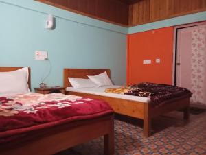 two beds in a room with red and blue walls at EHI Homestay Kurseong in Kurseong +1 photo