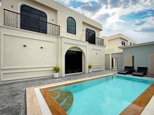 a large house with a swimming pool in the yard at FLEX Pool Villa in Pattaya