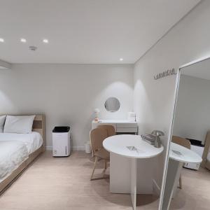 a bedroom with a bed and a table and a desk at Staymoment in Seoul