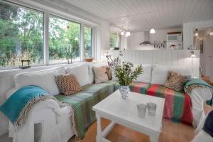 un salon avec un canapé blanc et une table dans l'établissement 12251-1-Sjaellands-Odde-Hyggebovej-3, à Tjørneholm