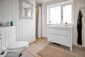 une salle de bain avec toilettes, lavabo et miroir dans l'établissement 12251-1-Sjaellands-Odde-Hyggebovej-3, à Tjørneholm