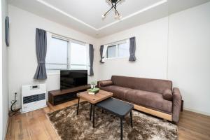 een woonkamer met een bank en een tafel bij Anax Nord 203 in Sapporo +83 foto's