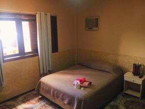 ein Schlafzimmer mit einem Bett mit ausgestopftem Elefant drauf in der Unterkunft El Guembe Hostel House in Puerto Iguazú