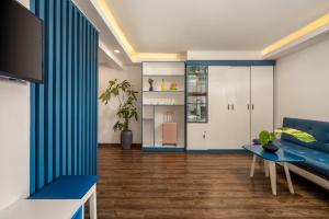 uma sala de estar com um sofá azul e uma mesa em Dana Sea Ngoc Bich em Da Nang