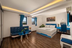 a bedroom with a bed and a couch and a table at Dana Sea Ngoc Bich in Da Nang