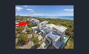 an aerial view of a large house with a red flag at Beachside House in Sebel Resort in Twin Waters