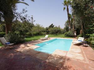 a swimming pool with two lounge chairs next to it at Villa sherazade Agadir, petit déjeuné offert in Agadir