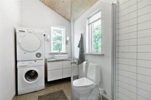 a bathroom with a toilet and a washing machine at 11153-Nykobing-Sj-Lyngvejen-27 in Nykøbing Sjælland +14 photos