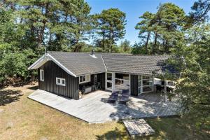 a small black house with a deck at 11153-Nykobing-Sj-Lyngvejen-27 in Nykøbing Sjælland