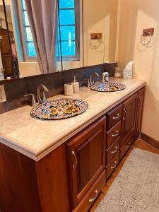 a bathroom counter with two sinks with plates on it at Birders' Paradise With Private Pool & Epic Views in Santa Elena