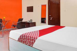 a bedroom with a large bed with a red and white blanket at Hotel O The Buddha Residency in Dānāpur