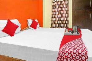Un dormitorio con una cama con almohadas rojas y blancas. en Hotel O The Buddha Residency, en Dānāpur