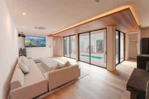 Una sala de estar con un sofá y un televisor. en ロマン詰まる大人のプレミアムヴィラ,プール,ゴルフ,ガレージ,BBQ ---Surf up---, en Ichinomiya 66 fotos más