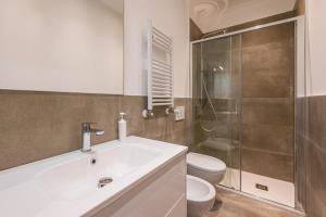 a bathroom with a sink and a toilet and a shower at Vaga's Nest - Modern Studio Apartment in Milan +9 photos