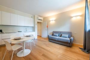 a living room with a table and a couch at Vaga's Nest - Modern Studio Apartment in Milan