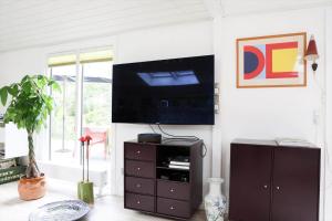 10013-1-Nykobing-Sj-Chr-Petersensvej-35 في Rørvig: غرفة معيشة مع تلفزيون على الحائط