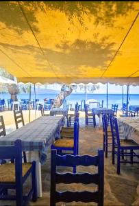 a group of tables and chairs under a tent at Marathias beach Miss Asimenia in Milína