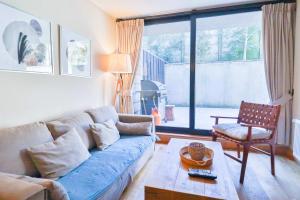 Una sala de estar con un sofá azul y una mesa. en HOM I Piscina, Estacionamiento Privado y terraza, en Puerto Varas