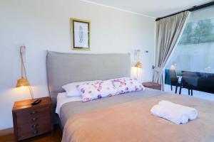 Un dormitorio con una cama con dos toallas encima. en HOM I Piscina, Estacionamiento Privado y terraza, en Puerto Varas