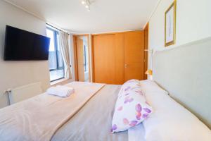 Un dormitorio con una cama con una almohada encima. en HOM I Piscina, Estacionamiento Privado y terraza, en Puerto Varas