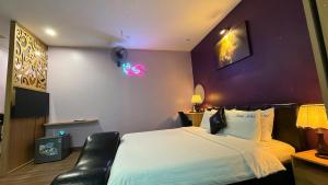 a bedroom with a bed and a black leather chair at Dream Hotel in Hanoi