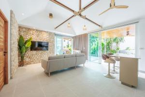 a living room with a couch and a tv at Baan Saint-Tropez Seaview Villas Kata Beach in Kata Beach